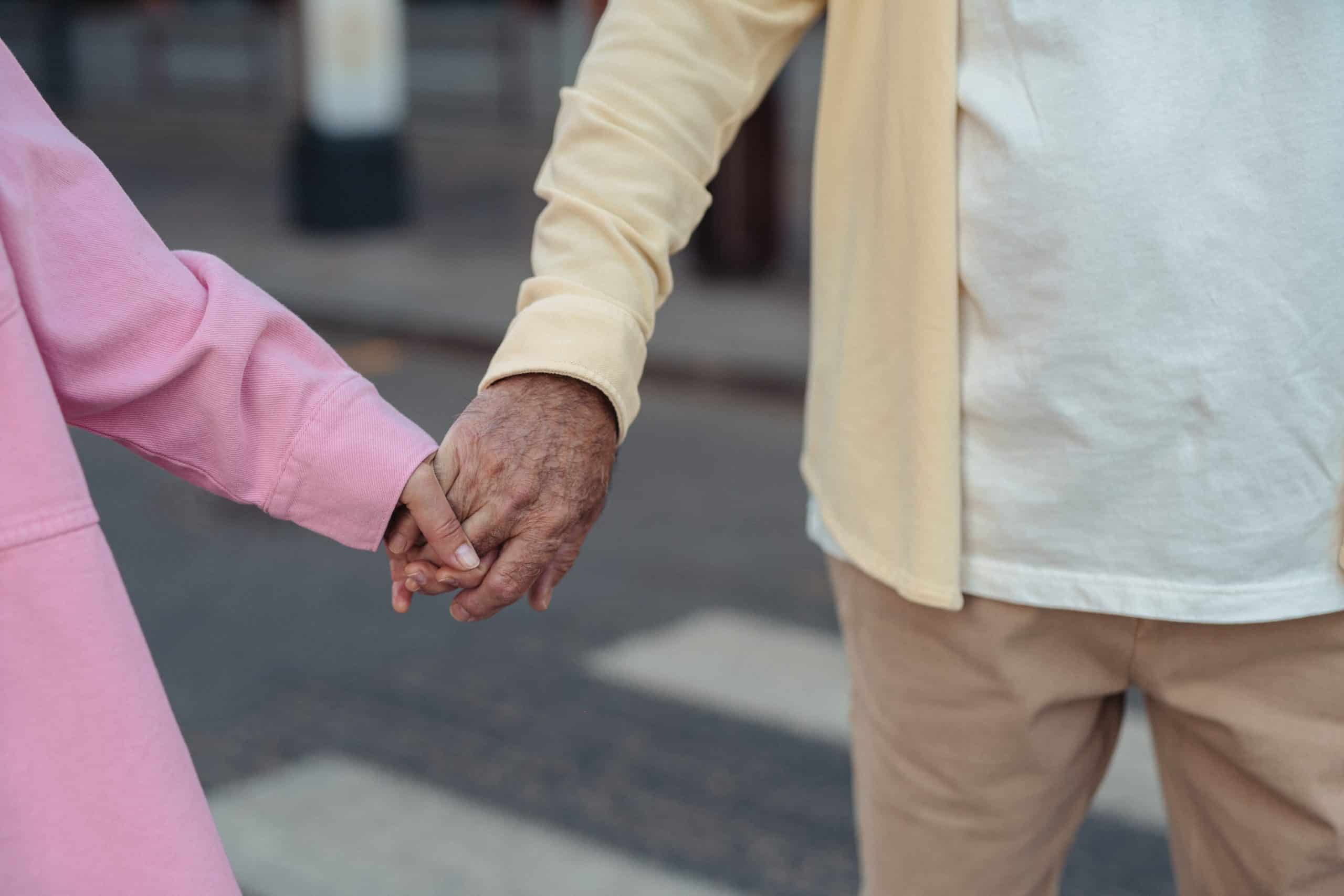 male and female senior citizens holding hands